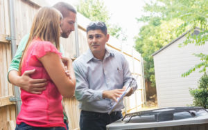 technician discussing hvac with homeowners